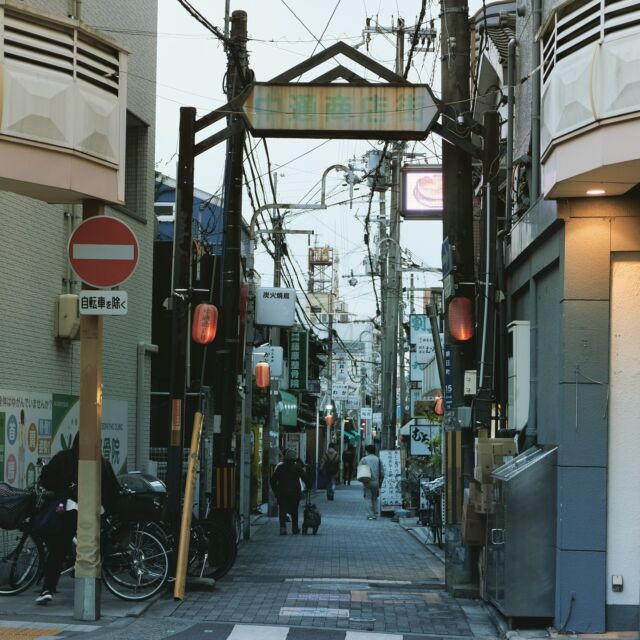 大阪府は吹田市、JR吹田駅の近く、大通りの脇の細道にあるのは中通商店街。

大通りから少し入ったところに設置されており、配色も相まって失礼ながらちょっと存在感が薄いアーチ。商店街というより横丁と呼びたい感じの狭い通りです。

この通りは別名「軍艦通り」と言うそうですが、由来はよくわかりませんでした。

ちなみに大阪の通天閣近くにあるジャンジャン横丁はかつて軍艦横丁と呼ばれていて、行き交う人々が身体をかわさねばならないほど狭い路地であったことから、軍艦の通路との連想で名づけられたとのこと。

今も人通りはありますが、この商店街もかつての往来はすごかったのでしょうかね。

Entrance arch of Nakadori shoppingstreet at Suita city, Osaka, Japan.
2022
#アーチ看板 #アーチ #商店街 #商店街ゲート #街歩き #大阪府 #吹田市 #中通商店街 #arch #street #japan_photo #japan #Osaka #Suita #ノスタルジー #軍艦通り #横丁 #吹田 #路地 #路地裏