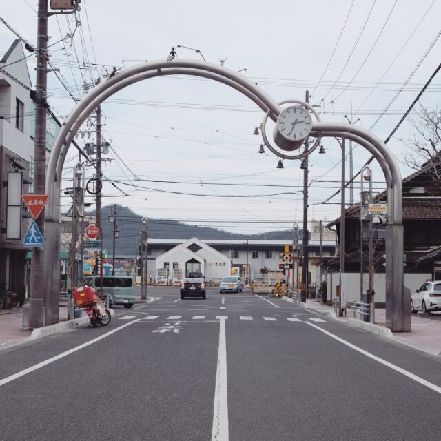 岐阜県は各務原市、JR那加（なか）駅を南に出てすぐにあるのは那加商店街のアーチ。

アーチに設置された防犯カメラには「那加本町通り商店街振興組合」とありますが、お店の人たちもこのあたりにいくつかある振興組合の商店街をまとめて「那加商店街」と呼んでいるようです。

那加には大正時代に旧日本軍の飛行場が作られ、現在も航空自衛隊が利用する基地があります。さらに学校や工場も作られ、人が集まるようになった駅前に続々と店ができていったのがこの商店街の始まりだそうです。

左右非対称の金属のアーチは時計付き。よく見ると人のようなものが飛び跳ねてます。

Entrance arch of Naka shopping street, Kakamigahara city, Gifu, Japan 
2022
#アーチ看板 #アーチ #商店街 #商店街ゲート #街歩き #岐阜県 #各務原市 #那加 #arch #street #japan_photo #japan #Gifu #Kakamigahara #Naka #時計 #鐘