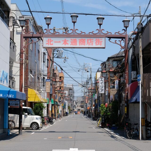 大阪府は大阪市住之江区、北一本通り商店街。加賀屋商店街の長いアーケードを北に抜けた先の住宅地（団地）をしばらく行くと見えてくるローカルな商店街です。

「北一本（きたいっぽん）」？って面白い名前の理由が何かあるのかと思ったのですが、どうも「北加賀屋」の「1丁目」にある「本通り」ということのようです。

北加賀屋はアートの街として売り出し中で、この周辺でもストリートアートをちらほら見かけます。このアーチと街並みもアートの一部ととらえてもいいと思うのですが。

Entrance arch of Kitaichihondori shopping street at Osaka city, Osaka, Japan.

2022
#アーチ看板 #アーチ #商店街 #商店街ゲート #街歩き #大阪 #住之江区 #北加賀屋 #arch #street #japan_photo #japan #Osaka #Suminoe #ノスタルジー #アート#北一本通商店街