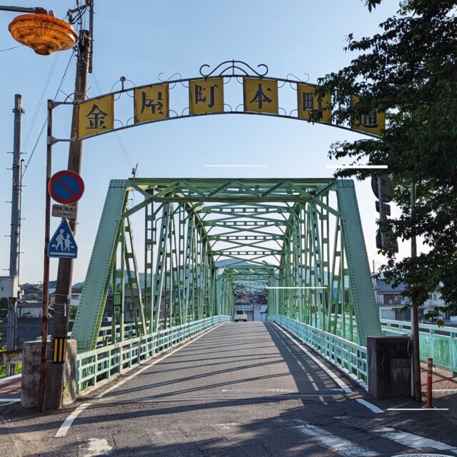 和歌山県は有田川町の金屋町本町通商店街。吉備町、清水町と合併し、現在の有田川町となる前の金屋町の中心部にあり、味のあるアーチや街路灯が残るローカル商店街です。

現在は最寄りのJR藤並駅からは5km以上離れていますが、写真の橋を渡った少し先には2002年に廃線となった有田鉄道の金屋口駅がありました（現在の有田町鉄道公園）。かつては沿線で取れたみかんを満載して走る「蜜柑列車」なる貨物車両が走っていたそうです(貨物営業は昭和59年に廃止されました)。

昭和30年に現在の橋がかけられる前は明治41年に作られた木造の橋がかかっていたようで、きっとこの上を人力でたくさんの蜜柑が運ばれていたのでしょう。

Entrance arch of Kanayachohonmachidori shopping street at Aridagawa town, Wakayama, Japan.

2023
#アーチ看板 #アーチ #商店街 #商店街ゲート #街歩き #和歌山 #有田川町 #金屋町 #arch #street #japan_photo #japan #Wakayama #Aridagawa #ノスタルジー